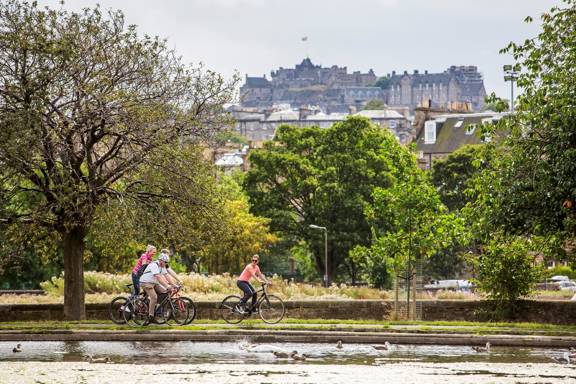 View of cyclists in Stirling Park with Stirling castle in the background