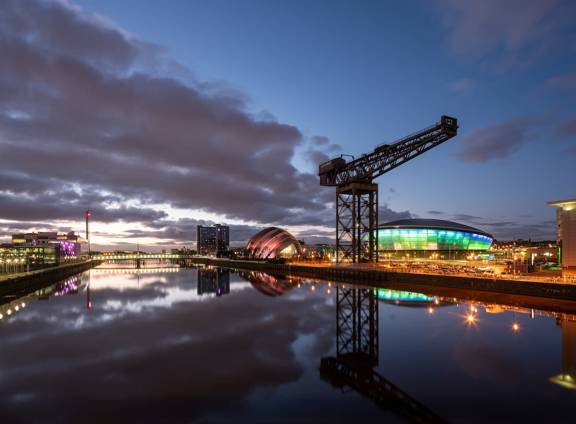 The River Clyde in Glasgow at sunset, with the Finnieston Crane, SSE hydro and SEC 'Armadillo' reflected in the still water