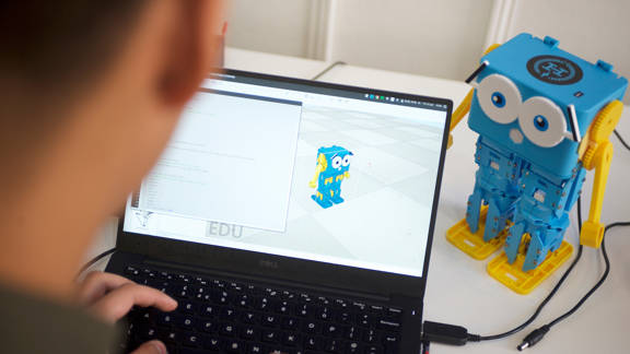 Man programming educational robot  called Marty