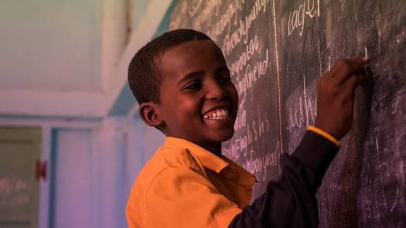 Child writing on blackboard