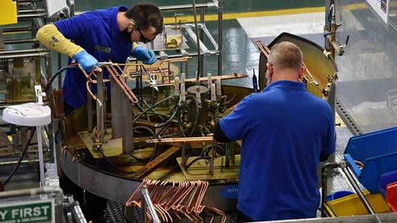 Two men working in Mitsubishi heat pump manufacturing facility