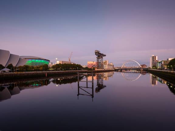 Twilight riverside view of Glasgow's Pacific Quay, with Scottish Entertainment Centre, Finnieston Crane and Clyde Arc bridge in distance